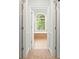 Hallway view into an elegant bathroom featuring a large arched window, soaking tub, and beautiful natural light at 8189 N Pine Cone N Dr, Villa Rica, GA 30180