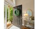 Open front door with a decorative wreath, showcasing a welcoming foyer and a view of the outdoors at 8189 N Pine Cone N Dr, Villa Rica, GA 30180