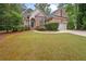 Brick home with mature trees, showcasing a well-maintained lawn and a spacious driveway at 8189 N Pine Cone N Dr, Villa Rica, GA 30180