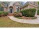 Home featuring manicured landscaping leading to a front entrance with an arched entryway and columns at 8189 N Pine Cone N Dr, Villa Rica, GA 30180