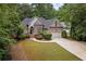 Beautiful single-Gathering home with lush landscaping, a circular driveway, and a classic brick facade at 8189 N Pine Cone N Dr, Villa Rica, GA 30180