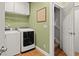Functional laundry room featuring modern washer and dryer units, tile flooring, and easy access to stairs at 8189 N Pine Cone N Dr, Villa Rica, GA 30180