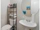 A pedestal sink is featured in this bathroom with the toilet and shelving to the left at 5622 Laurel Ridge Dr, Atlanta, GA 30344