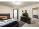 Carpeted bedroom with a dark wood bed frame, dresser, TV, and adjacent room with a desk at 5622 Laurel Ridge Dr, Atlanta, GA 30344