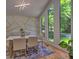 Modern dining room with a marble table, stylish chairs, and floor-to-ceiling windows offering a lush view at 2540 Rocky Springs Dr, Marietta, GA 30062