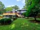 A spacious two-story home with a large wooden deck, lush green lawn, and mature landscaping at 2540 Rocky Springs Dr, Marietta, GA 30062