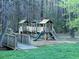 A community playground with slides, platforms, and a small bridge amid a wooded area at 2540 Rocky Springs Dr, Marietta, GA 30062