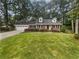 Charming brick home with a well-manicured lawn, an attached garage and mature trees at 4023 Oak Crest Dr, Tucker, GA 30084