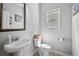 Charming powder room featuring a pedestal sink, decorative mirror, and a window for natural light at 124 Freedom Dr, Acworth, GA 30102