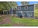 View of the home's blue siding and grassy backyard with mature trees at 1621 Northlake Springs Ct, Decatur, GA 30033