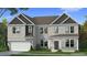 Charming two-story home with a gray brick exterior, complemented by a well-manicured lawn and lush landscaping at 2820 Dolce Rd, Dacula, GA 30019