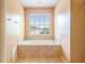 Bathtub in bathroom, with window and tiled surround at 1883 Jameson Cir, Lawrenceville, GA 30043
