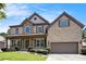 Charming two-story brick home boasts a landscaped lawn and welcoming front porch at 1883 Jameson Cir, Lawrenceville, GA 30043