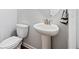 Powder room with pedestal sink, toilet, and updated fixtures at 3505 Aqua Point Pl, Cumming, GA 30041