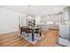 Open-concept dining area adjacent to kitchen, featuring hardwood floors and modern lighting at 3505 Aqua Point Pl, Cumming, GA 30041