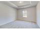 Bright bedroom featuring plush carpet, trim, and a window overlooking the wooded property at 161 Haverling Pass, Hampton, GA 30228
