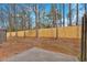 Backyard featuring a wood privacy fence, trees, and concrete slab patio at 1795 Waterside Nw Dr, Kennesaw, GA 30152