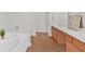 Bright bathroom featuring a large bathtub, wood floors, and a vanity at 1795 Waterside Nw Dr, Kennesaw, GA 30152
