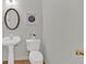 Stylish half bath with pedestal sink, oval mirror, and elegant decor at 1795 Waterside Nw Dr, Kennesaw, GA 30152