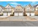Townhomes featuring two-car garages, light brown siding and a well maintained lawn at 1795 Waterside Nw Dr, Kennesaw, GA 30152