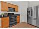Cozy kitchen with wood cabinets, stainless steel refrigerator, range and black countertops at 1795 Waterside Nw Dr, Kennesaw, GA 30152