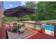 Relaxing deck with an outdoor dining set with shade and a refreshing pool view at 450 Ledbetter Rd, Villa Rica, GA 30180
