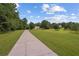 Long concrete driveway winding through a lush, green lawn leading to a home at 450 Ledbetter Rd, Villa Rica, GA 30180
