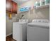 Functional laundry area with washer, dryer, and shelf space for cleaning supplies at 450 Ledbetter Rd, Villa Rica, GA 30180