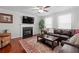 Cozy living room with fireplace, ceiling fan, and dark brown leather furniture at 450 Ledbetter Rd, Villa Rica, GA 30180