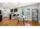 Bright dining area with a modern table, wood floors, and an open layout to the kitchen at 1788 Campbellton Sw Rd, Atlanta, GA 30311