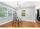 Sunlit dining area featuring a modern table, wood floors, and large windows at 1788 Campbellton Sw Rd, Atlanta, GA 30311