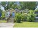 Charming single-story home featuring a blue door, stone accents, and lush landscaping at 1788 Campbellton Sw Rd, Atlanta, GA 30311