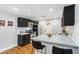 Bright kitchen with black cabinets, granite countertops, stainless appliances, bar seating, and hardwood floors at 1788 Campbellton Sw Rd, Atlanta, GA 30311