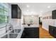 Modern kitchen featuring granite countertops, black cabinets, stainless steel sink and hardwood floors at 1788 Campbellton Sw Rd, Atlanta, GA 30311