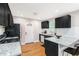 Well-lit kitchen with black cabinets, stainless steel appliances, granite countertops, and hardwood flooring at 1788 Campbellton Sw Rd, Atlanta, GA 30311
