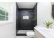 Modern bathroom with stylish dark tiled shower, golden fixtures, and a floating vanity at 2099 Redbud Sw Ct, Marietta, GA 30008