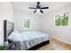 Bedroom featuring wood flooring, a ceiling fan, and view of a wooded area through the windows at 2099 Redbud Sw Ct, Marietta, GA 30008