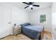 Bedroom features wood flooring, a ceiling fan, a nightstand, and a view of the outdoors through the windows at 2099 Redbud Sw Ct, Marietta, GA 30008