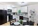 Modern kitchen boasts white cabinets, black appliances, and sleek countertops with a stone backsplash at 2099 Redbud Sw Ct, Marietta, GA 30008