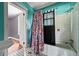 Bright bathroom features a shower with floral curtains, a large tub, and teal colored walls at 10 Shadburn Ferry Rd, Buford, GA 30518