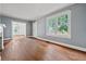 An empty living room with wood floors, light blue walls, two windows and white trim at 10 Shadburn Ferry Rd, Buford, GA 30518