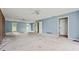 Large empty living room with outdated carpet, light blue walls, and two windows; ready for a modern makeover at 10 Shadburn Ferry Rd, Buford, GA 30518
