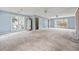 Large empty living room with outdated carpet, light blue walls, and two windows; ready for a modern makeover at 10 Shadburn Ferry Rd, Buford, GA 30518
