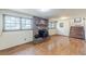 Basement featuring a brick fireplace, windows, hardwood flooring, a staircase, and white paneled walls at 1737 Fontaine Dr, Jonesboro, GA 30236