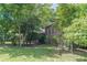 View of a two-story home featuring a brick chimney and surrounded by lush trees at 1737 Fontaine Dr, Jonesboro, GA 30236