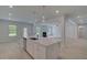 Open kitchen island with stainless steel appliances and a view of the living room with a fireplace at 197 Haverling Pass, Hampton, GA 30228