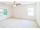 Bright bedroom with ample natural light, ceiling fan, and neutral carpet for a comfortable ambiance at 7567 Waverly Loop, Fairburn, GA 30213