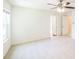 Spacious bedroom with neutral carpet, ceiling fan, and two doorways offering versatility at 7567 Waverly Loop, Fairburn, GA 30213
