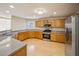 Open kitchen with ample counter space, stainless steel appliances, and light wood cabinets at 7567 Waverly Loop, Fairburn, GA 30213