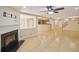 Open living room with a decorative fireplace, ceiling fan, and light wood flooring throughout at 7567 Waverly Loop, Fairburn, GA 30213